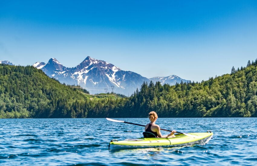 Eine Frau genießt es, auf einem See Kanu zu fahren.
